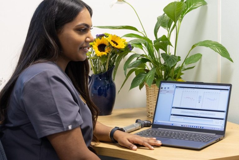 Female Audiologist sitting at her desk with her laptop